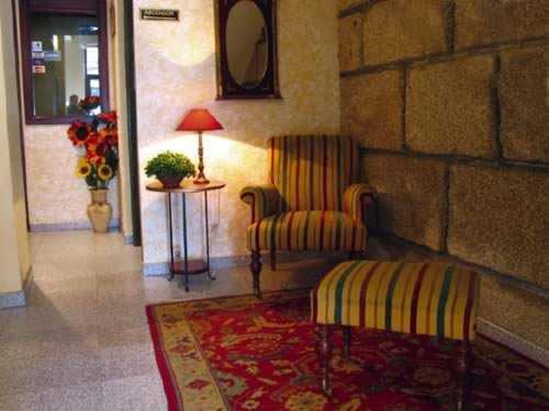 a room with a chair and a table and a lamp at Hotel Casablanca Vigo in Vigo