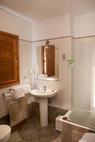 a bathroom with a sink and a toilet and a tub at Apartamentos Cuevas del Mar in Nueva de Llanes