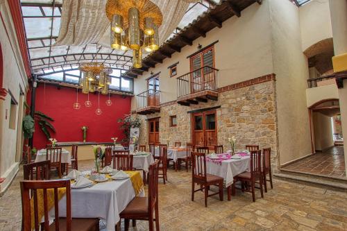 a dining room with tables and chairs in a building at Hotel San Marcos in San Cristóbal de Las Casas