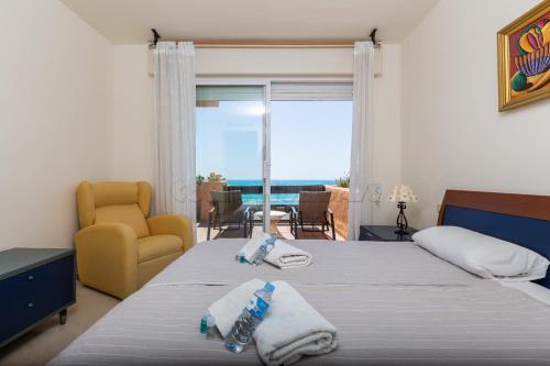 a bedroom with a bed and a view of the ocean at los granados 1221 in Manilva