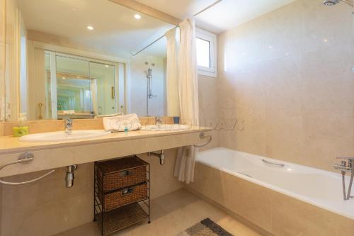 a bathroom with a tub and a sink and a bath tub at los granados 1221 in Manilva