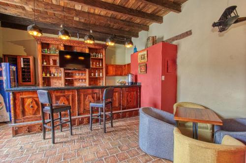 a kitchen with a bar with chairs and a refrigerator at Hotel San Marcos in San Cristóbal de Las Casas