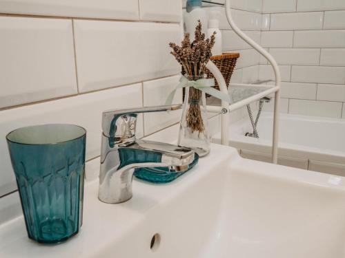 a sink with a toothbrush and a glass on it at Business and Travel Central Apartment in Timişoara