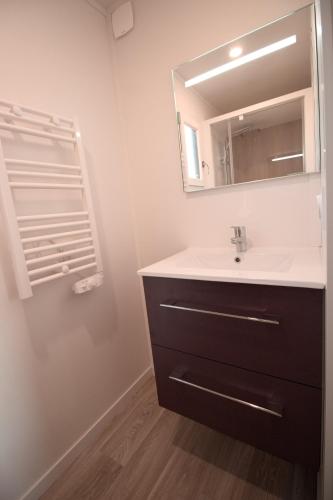 une salle de bain avec un lavabo et un miroir dans l'établissement Les Logis de la Seugne, à Saint-Germain-de-Lusignan