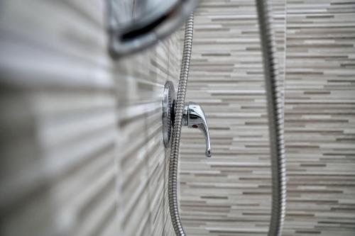 a shower with a hose attached to a wall at B&B Milena in Paceco