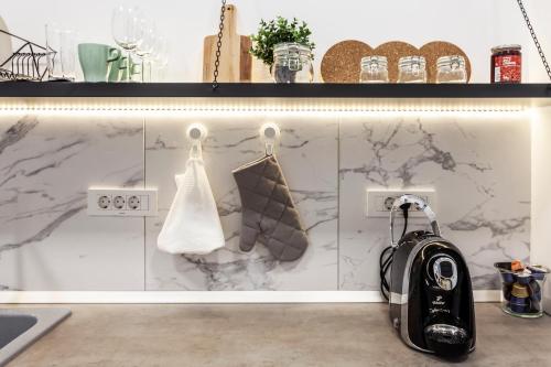 a kitchen with marble walls and a black backpack at Martin Boutique Hotel in Plauen