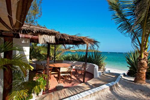 a table and chairs on the beach with the ocean at Ocean Sports Resort in Watamu