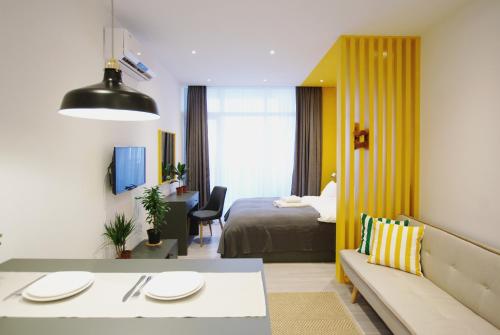 a living room with a couch and a bed in a room at Banana Apartments in Batumi