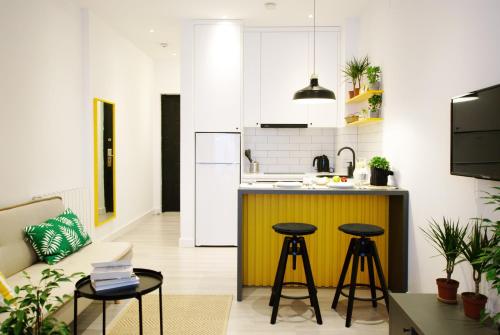 Banana Apartments في باتومي: مطبخ مع كونتر وكراسي في غرفة