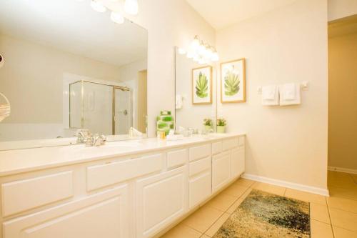 La salle de bains est pourvue de 2 lavabos et d'un grand miroir. dans l'établissement Vista Cay Luxury 3 bedroom condo (#3103), à Orlando
