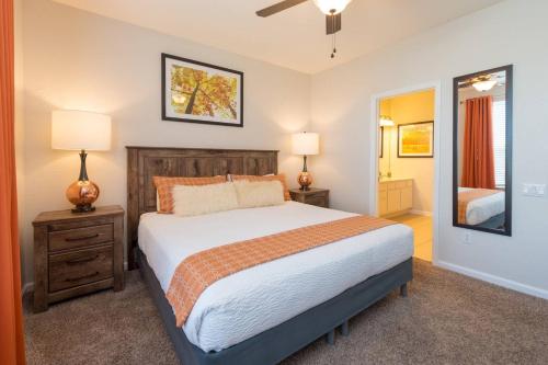 een slaapkamer met een bed, 2 lampen en een spiegel bij Vista Cay Luxury 3 bedroom Townhouse (#3105) in Orlando