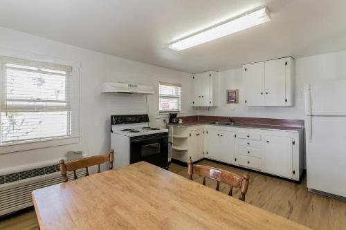a kitchen with white cabinets and a table and a refrigerator at Skylark Shores Resort in Lakeport