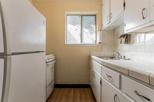 a kitchen with a white refrigerator and a sink at Skylark Shores Resort in Lakeport