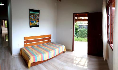 1 dormitorio con 1 cama con cabecero de madera en Monsal Casa para Temporada, en Florianópolis