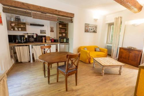 a living room with a table and a yellow couch at Havre de paix en Provence in Lauris