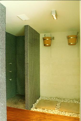 a bathroom with a walk in shower with two sinks and a shower at Hotel Milano Alpen Resort Meeting&Spa in Castione della Presolana