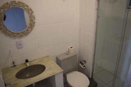 La salle de bains est pourvue d'un lavabo, de toilettes et d'un miroir. dans l'établissement Flat Vila Aju, à Aracaju