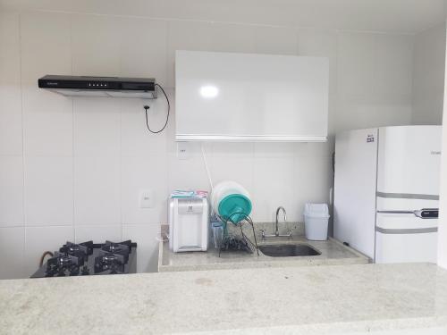 a white kitchen with a sink and a refrigerator at Aldeia dos reis - Condado - Mangaratiba - Loft 405 bl 3 in Mangaratiba