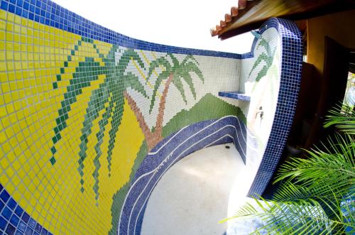 a mosaic mural of palm trees on a wall at Hotel Vista de Olas in Santa Teresa Beach