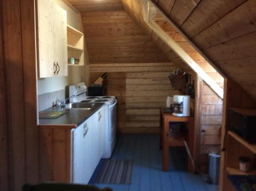a kitchen in a log cabin with a staircase at Domaine Montauban in Saint Fortunat