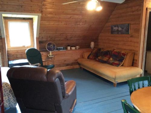 a living room with a couch and chairs in a cabin at Domaine Montauban in Saint Fortunat
