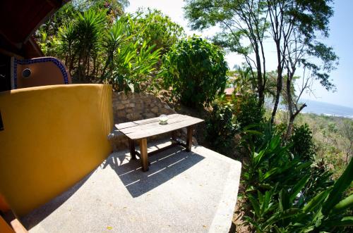 a wooden picnic table sitting on a concrete patio at Hotel Vista de Olas in Santa Teresa Beach