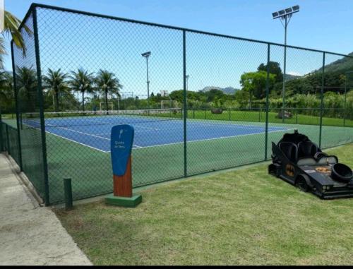 a chain link fence with a tennis court at Aldeia dos reis - Condado - Mangaratiba - Loft 405 bl 3 in Mangaratiba