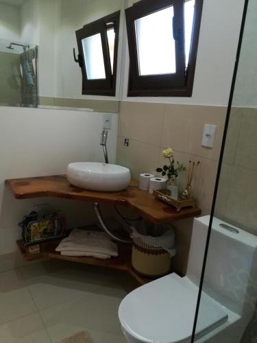 a bathroom with a sink and a toilet and a mirror at Viena Hospedaria in Treze Tílias