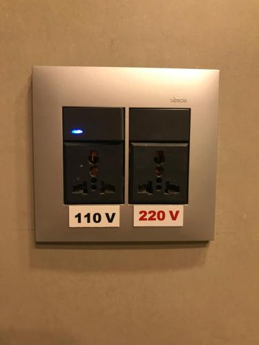 a lightswitch on a wall with two clocks on it at Winter Suites Campos do Jordão - Capivari in Campos do Jordão