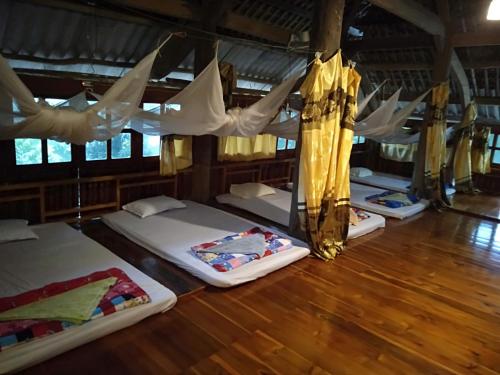 a group of four beds in a room at Giang Tien Homestay-VuLinh Farmstay ThacBa in Yên Bình