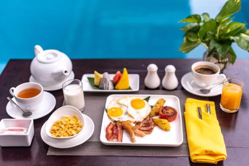 a table with a breakfast plate of breakfast foods and coffee at Siem Reap Palace Hotel & Spa in Siem Reap