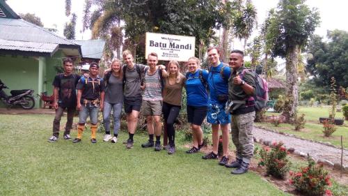a group of people standing in front of a sign at Wisma Batu Mandi and offers jungle tours in Bukit Lawang