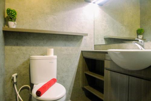 ein Badezimmer mit einer weißen Toilette und einem Waschbecken in der Unterkunft Homey 1BR at 15th Floor Apartment at Atlanta Residences By Travelio in Depok