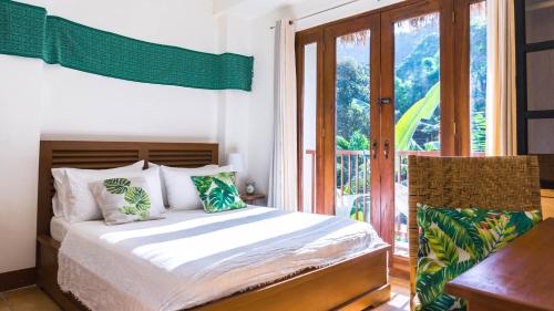 a bedroom with a bed and a balcony at Talisay Boutique Hotel in El Nido