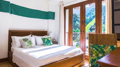 a bedroom with a bed and a balcony at Talisay Boutique Hotel in El Nido