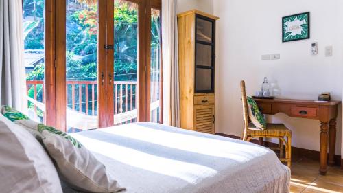 a bedroom with a bed and a desk and a window at Talisay Boutique Hotel in El Nido
