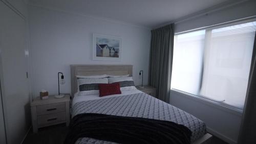 a bedroom with a large bed and a window at Stylish Holiday Unit in Bridport