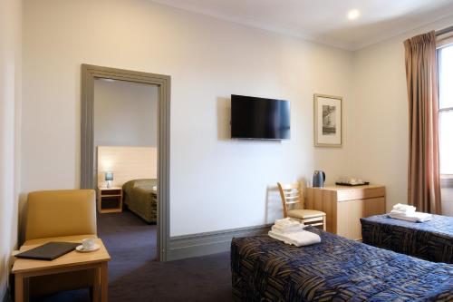 Habitación de hotel con 2 camas y espejo en Royal Exhibition Hotel en Sídney