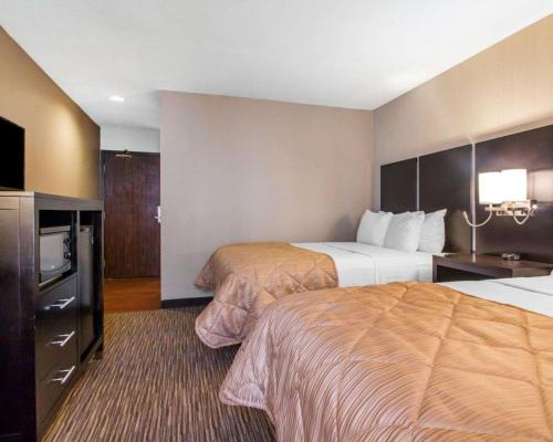 a hotel room with two beds and a television at Greenstay Inn & Suites Court View in Springfield