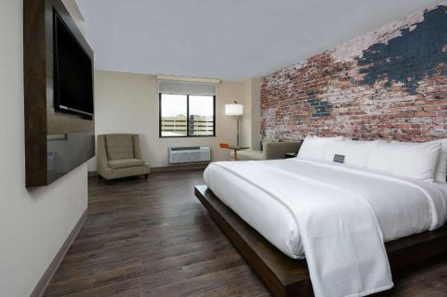 a bedroom with a large bed and a brick wall at The Lodge at Duke Medical Center in Durham