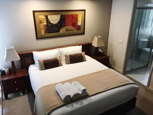 ein Schlafzimmer mit einem Bett mit zwei Handtüchern darauf in der Unterkunft luxury abalina cottages in Bright