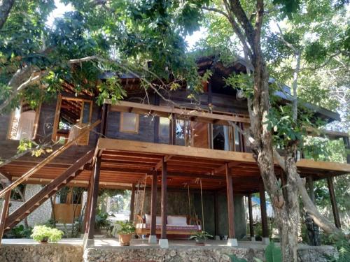 una casa en el bosque con un árbol en Tevana House Reef, en Bira