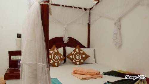 1 dormitorio con 1 cama con dosel en Mango Villa Sigiriya, en Sigiriya