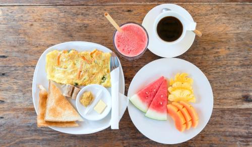 ein Tisch mit zwei Tellern Frühstücksessen und einer Tasse Kaffee in der Unterkunft Giliranta in Gili Trawangan