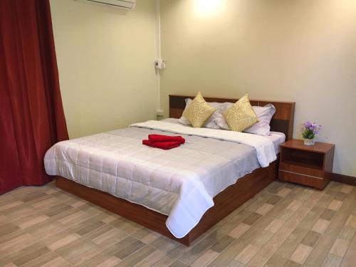 a bedroom with a bed with a red shirt on it at นพรัตน์การ์เด้นฮิลล์ in Uthai Thani