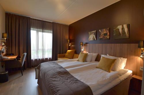 a hotel room with a large bed and a window at Skara Konsthotell in Skara