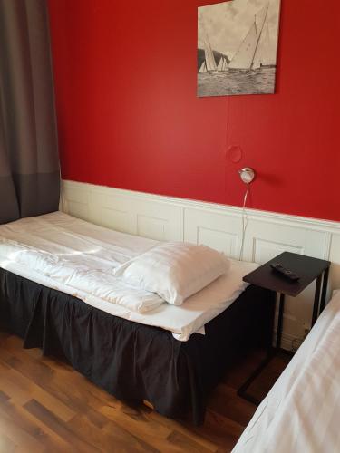 a bed in a room with a red wall at Sure Hotel by Best Western Vilsta Sporthotell in Eskilstuna