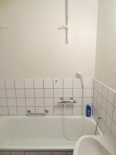 a bathroom with a bath tub and a sink at Hotel Göingehof in Hässleholm