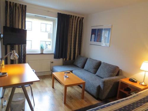 a living room with a couch and a table at Hotel Göingehof in Hässleholm