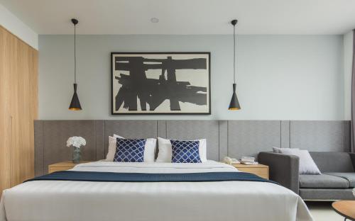 a bedroom with a large bed and a couch at Altos Hotel in Phnom Penh